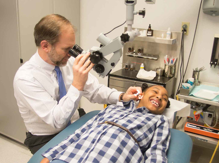 Dr. Smith testing a pediatric patient for ear problems